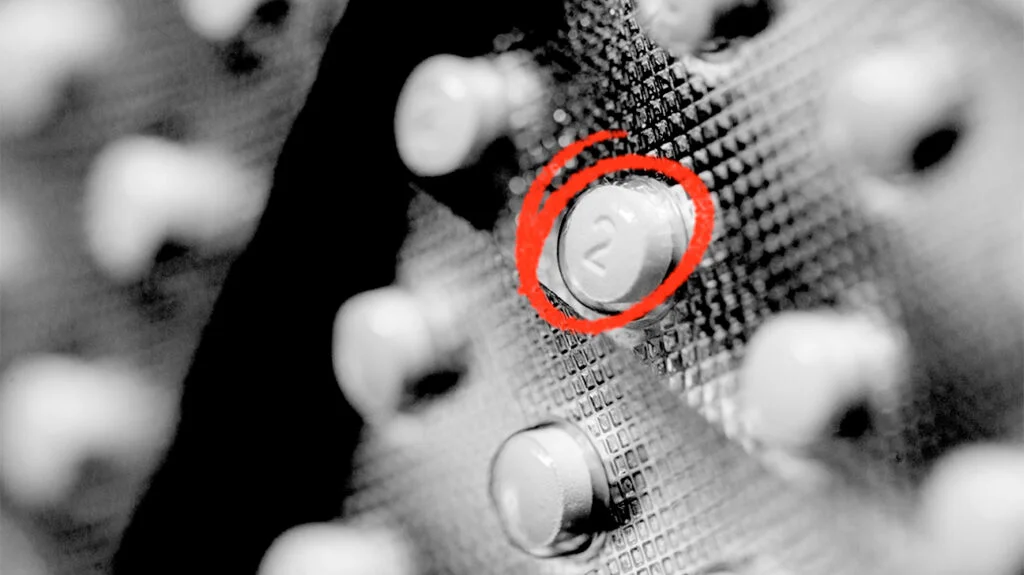Close-Up Image Of A Clenbuterol Pill With A Striking Red Circle, Illustrating Its Specific Characteristics And Branding.