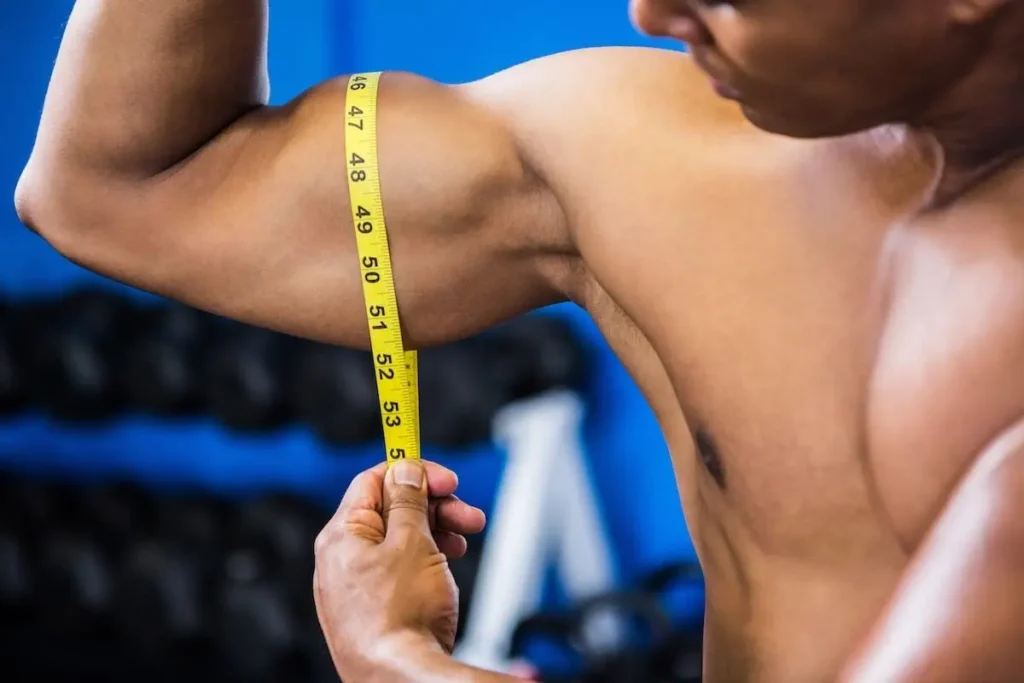 Showcasing Sarms Benefit: Muscle Growth, In A Gym Setting With Weights In The Background.